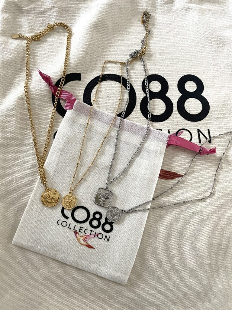 Quatre colliers en acier inoxydable dorés et argentés avec pendentif.