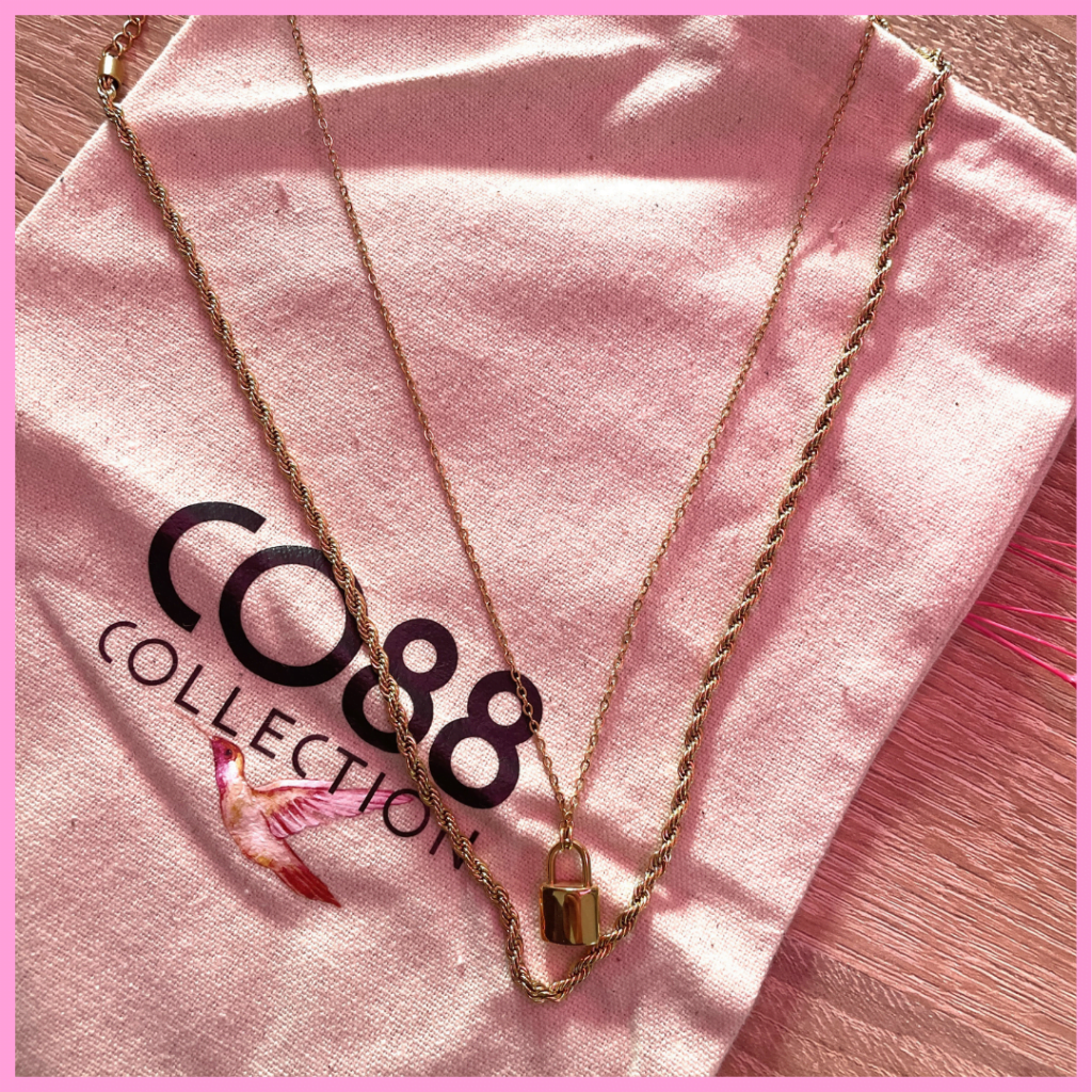 Deux collier CO88 en acier inoxydable doré. L'un est une chaine et le deuxième est agrémenté d'un pendentif cadenas