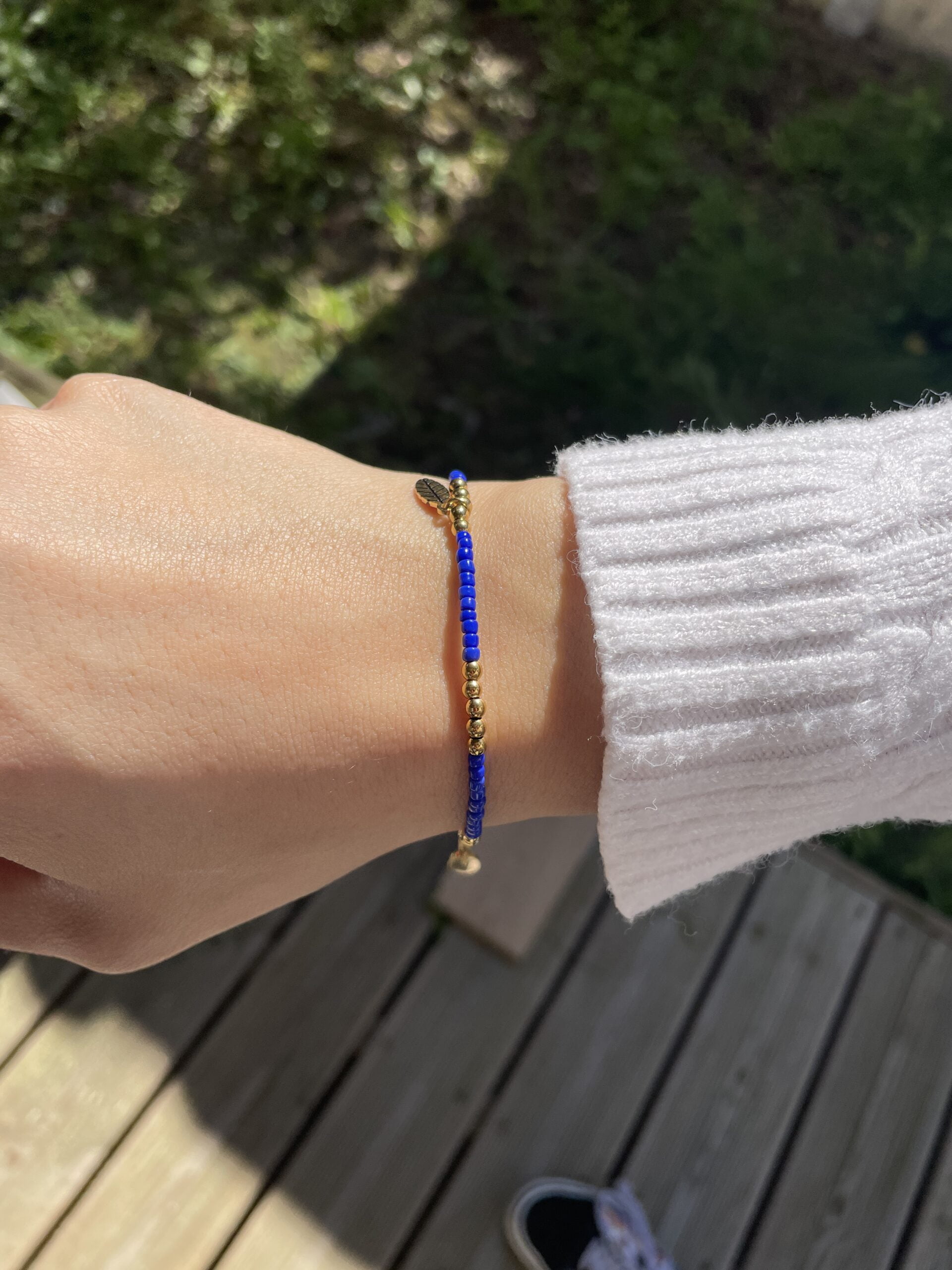 Bracelets Co88 France en acier inoxydable doré et perles bleu foncé, pampille feuille