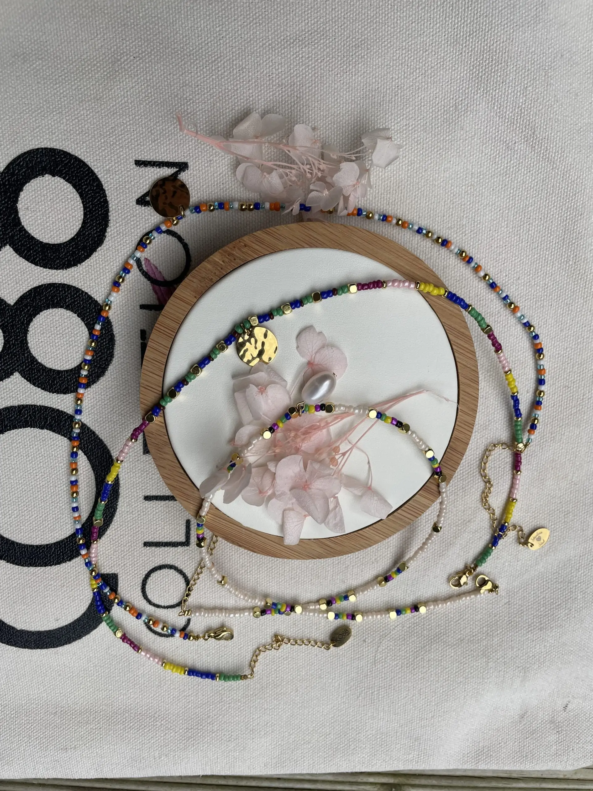 Composition bijoux Co88 France, bracelet et colliers en acier inoxydable et perles colorées, pampille dorée et perle d'eau douce